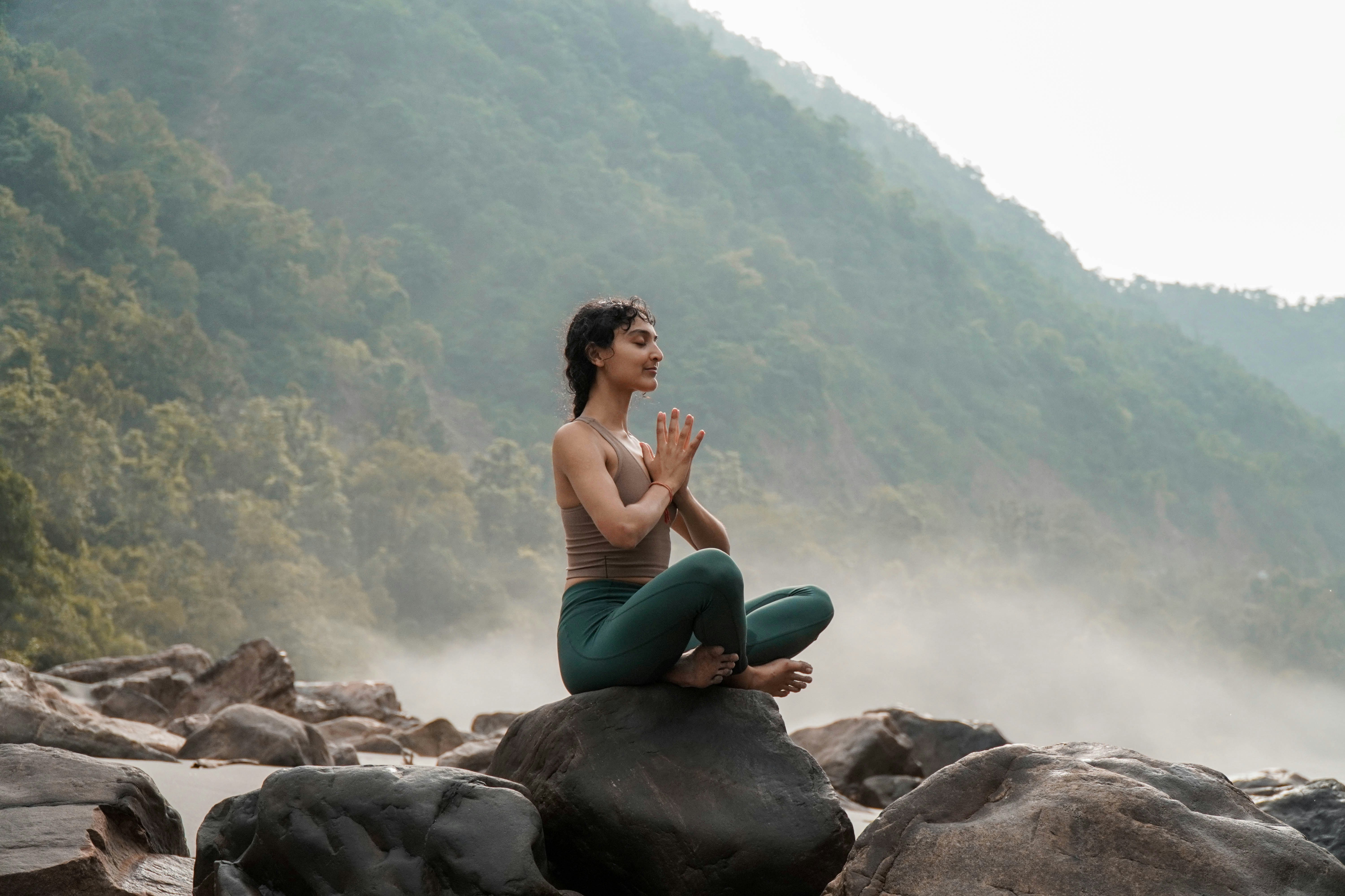 Donna in meditazione seduta sulle rocce
